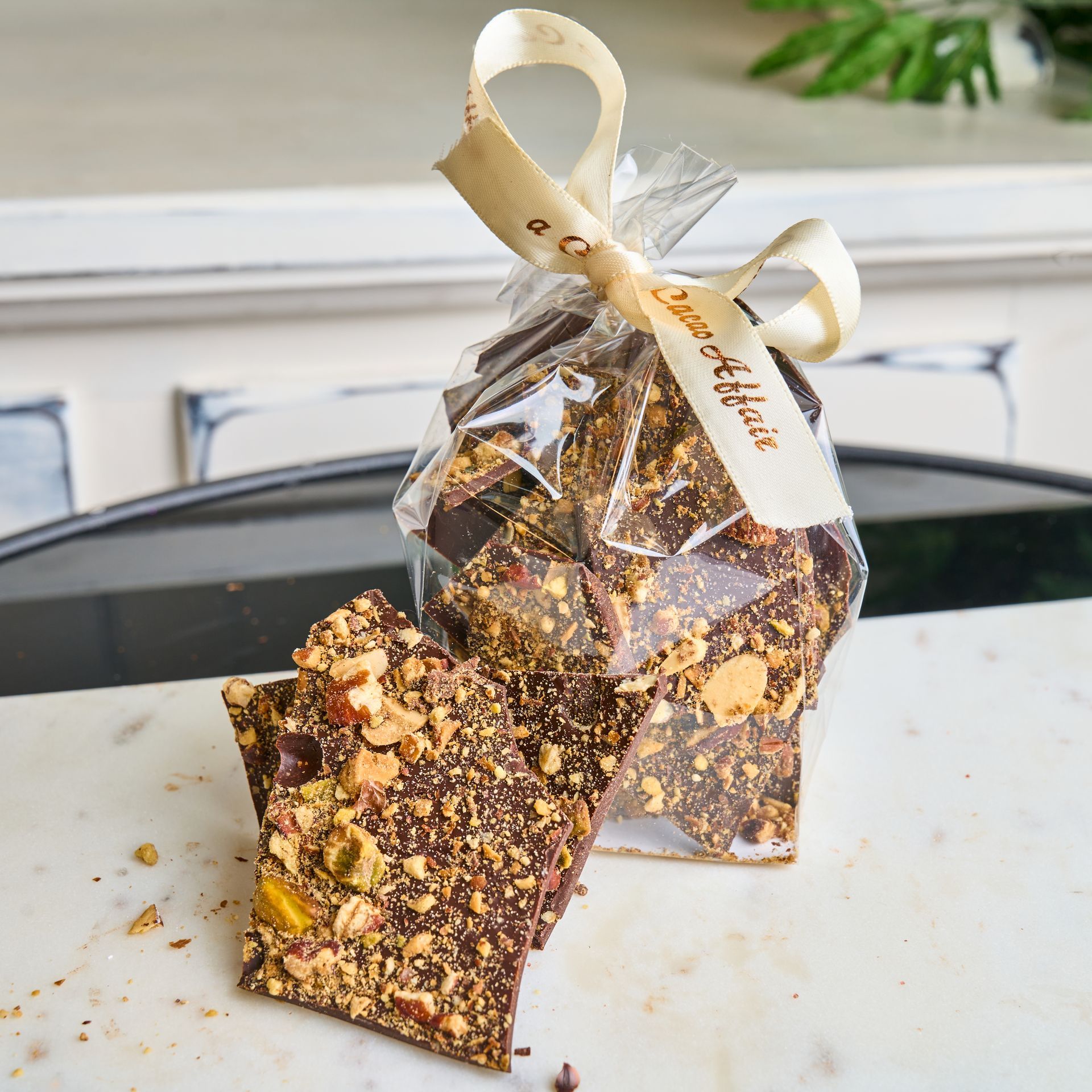 Chocolate toffee in a clear bag tied with a ribbon; pieces are visible, scattered on a surface.