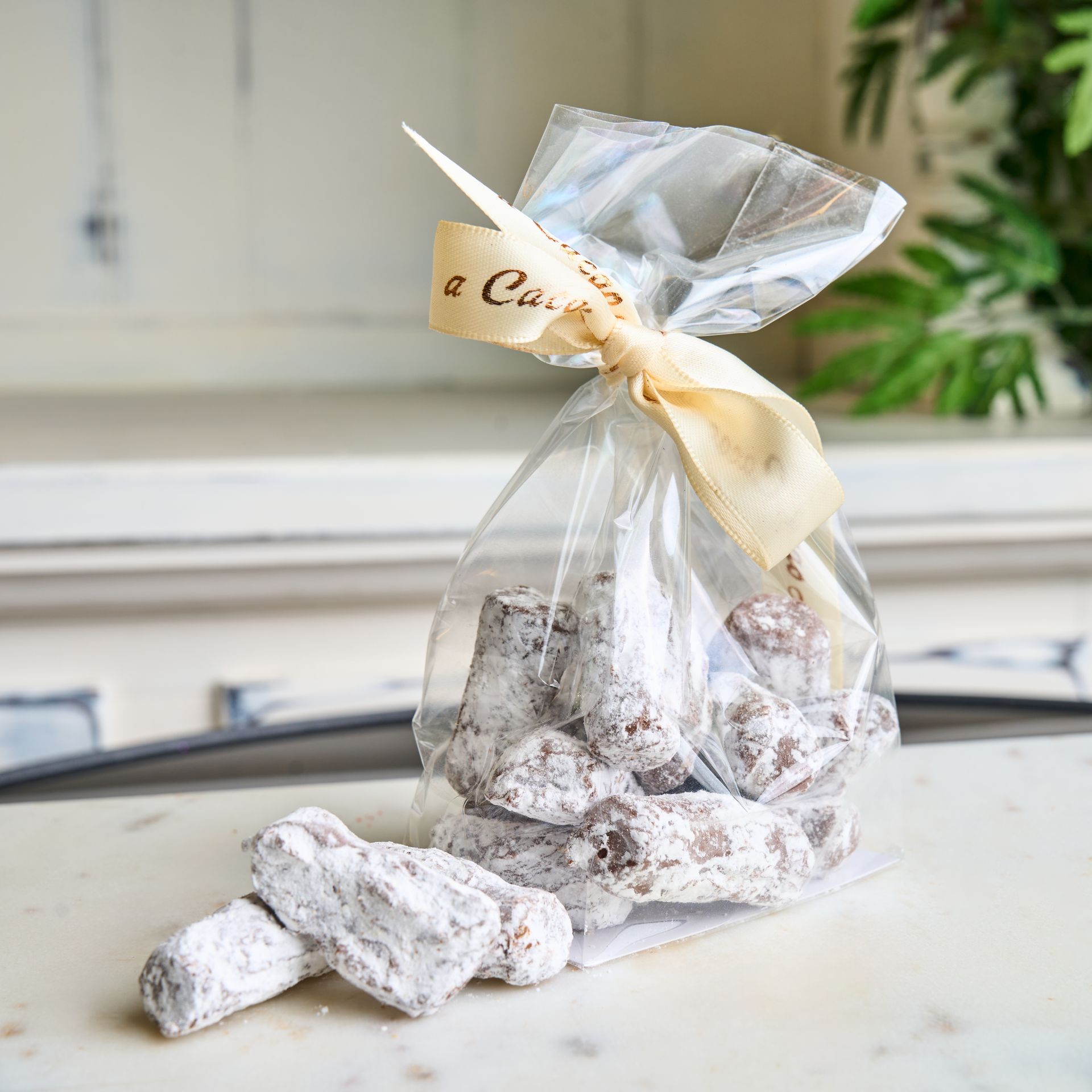 Bag of sugared chocolate treats tied with a beige ribbon.