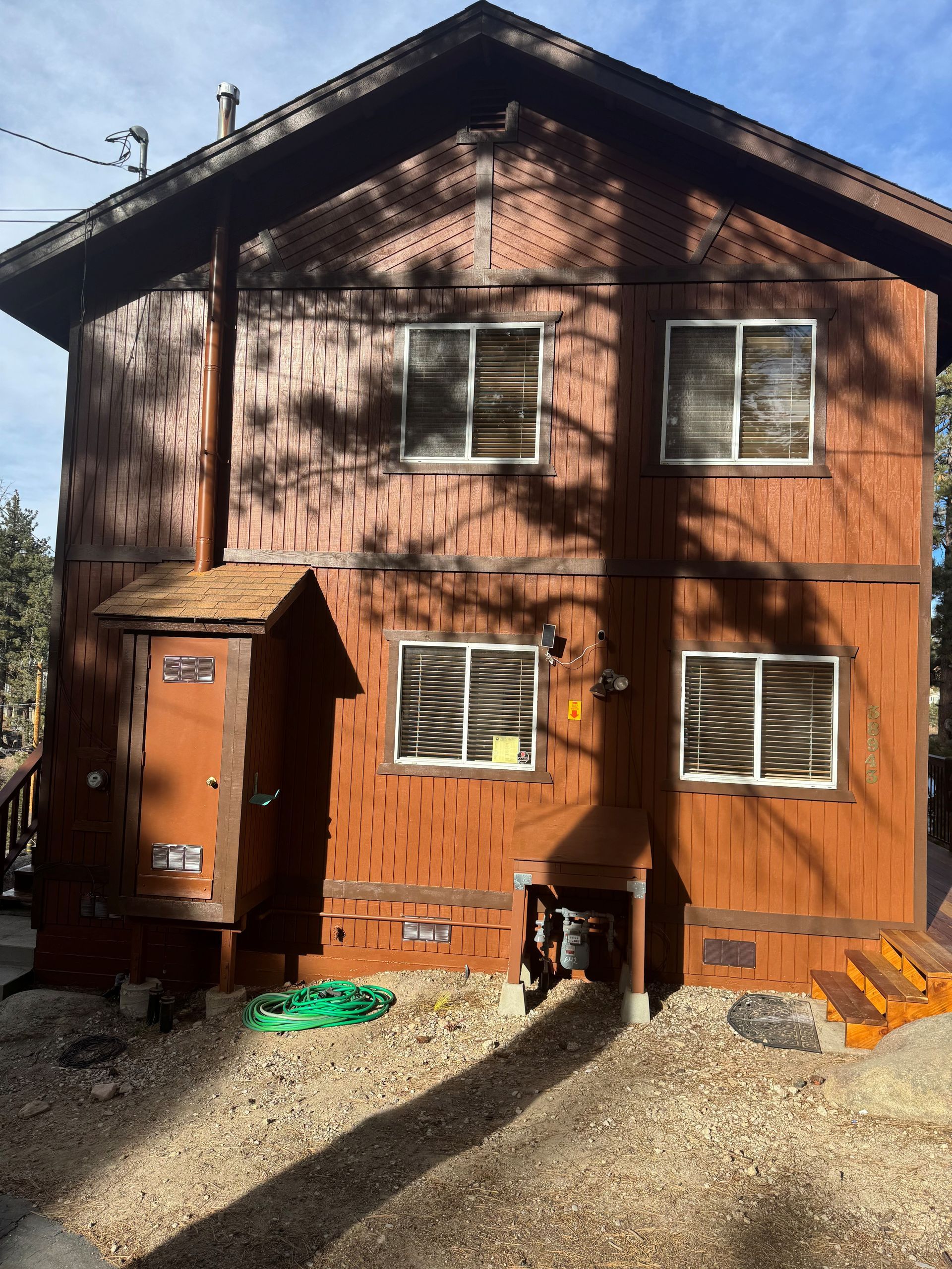 Two-story brown cabin with multiple windows, door and steps. Numbers 906, 905 and 904 are visible.
