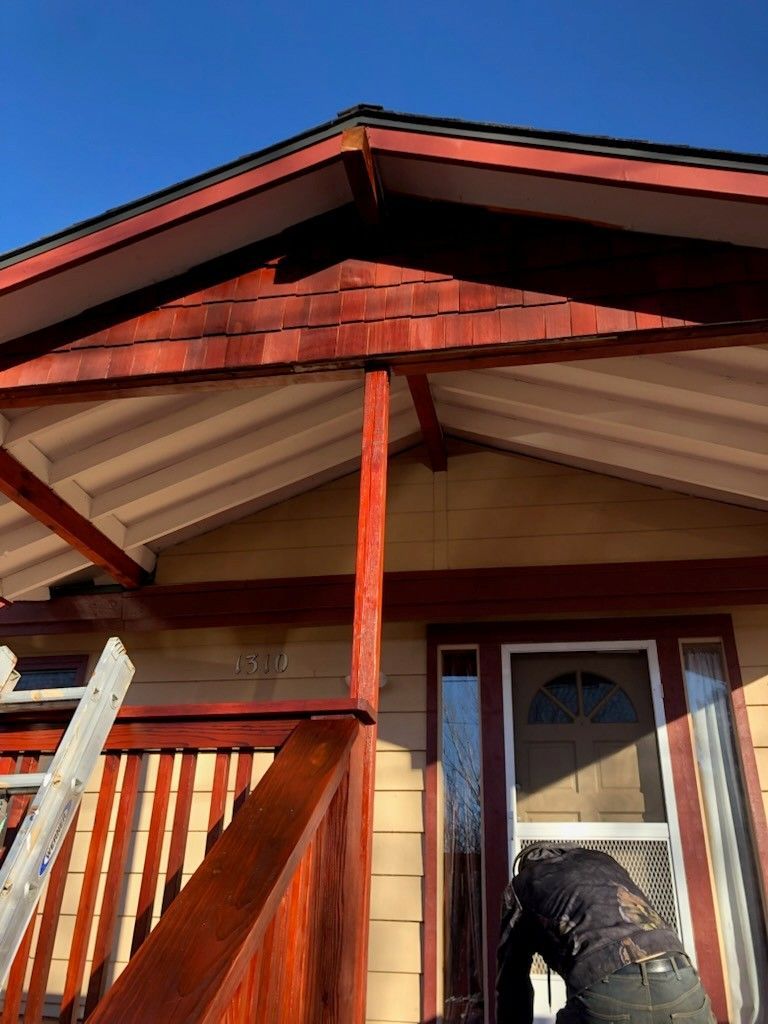 House exterior: red trim, yellow siding, wooden porch. Person on porch.