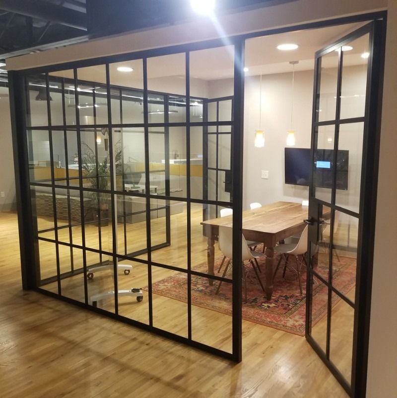 A room with a table and chairs behind a glass wall