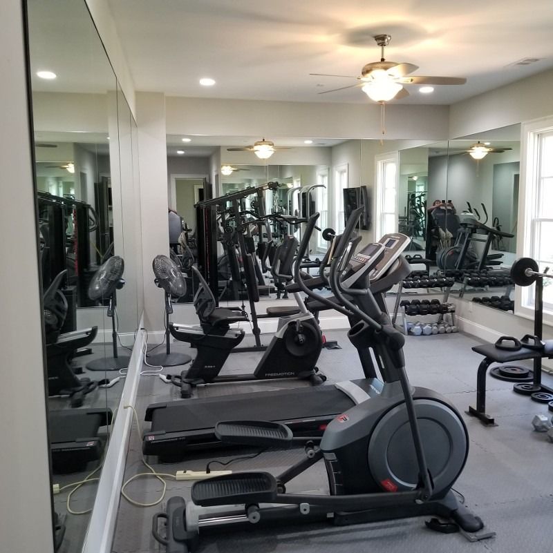 A gym with a lot of exercise equipment including an elliptical