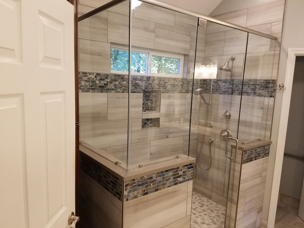 A bathroom with a walk in shower with sliding glass doors.