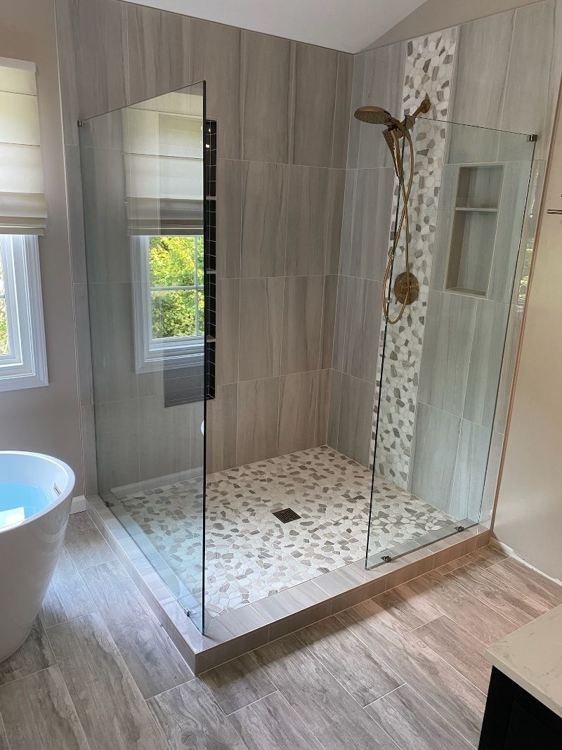 A bathroom with a walk in shower and a bathtub.