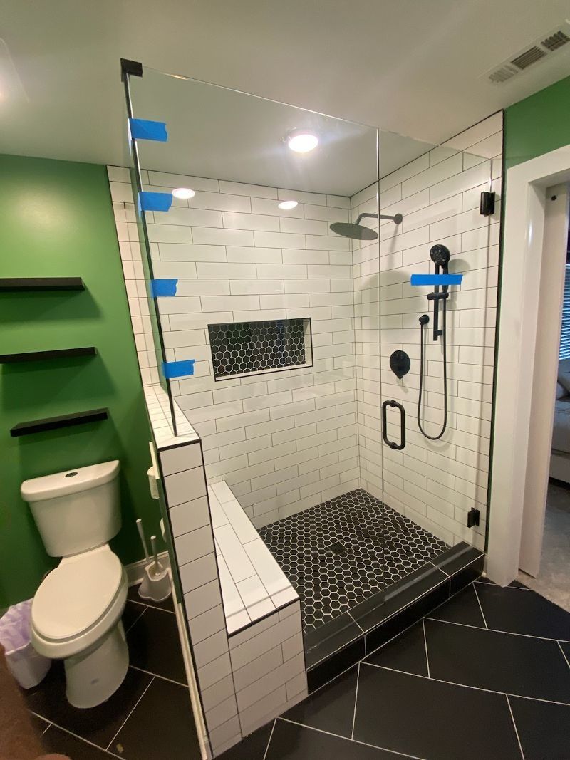 A bathroom with a toilet and a walk in shower.