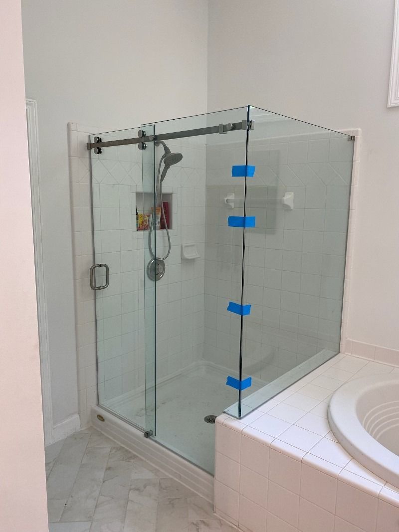 A bathroom with a walk in shower and a tub.