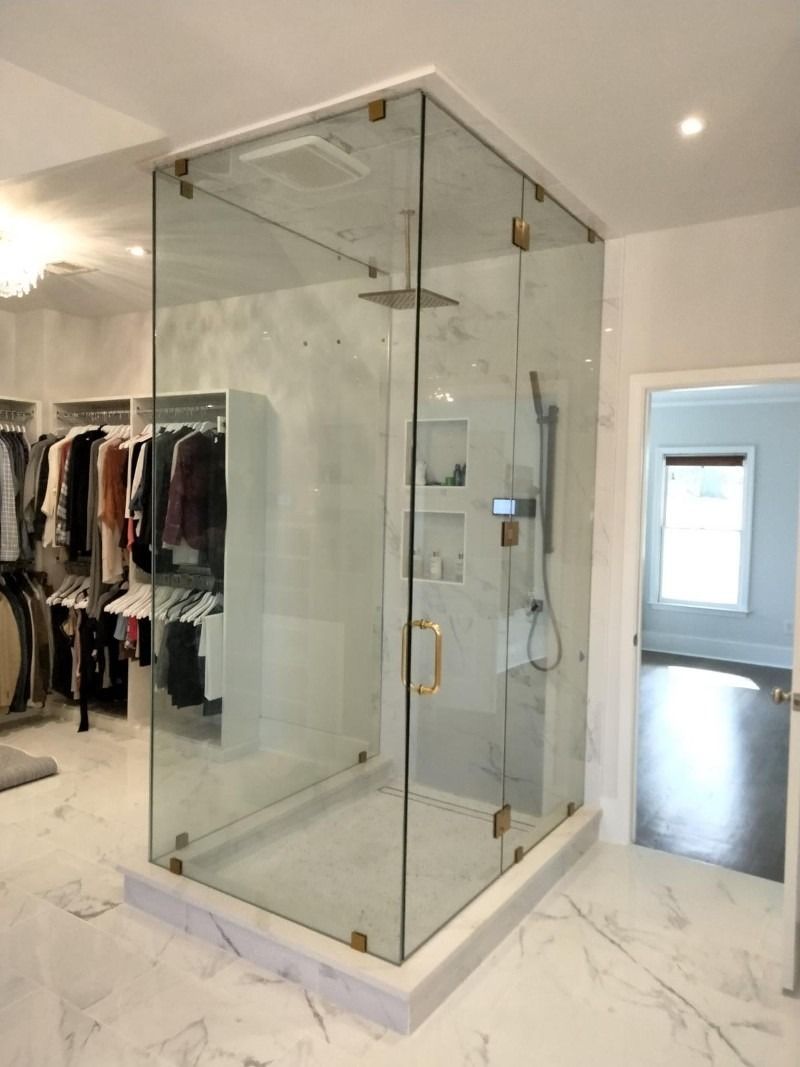 A walk in closet with a glass shower stall