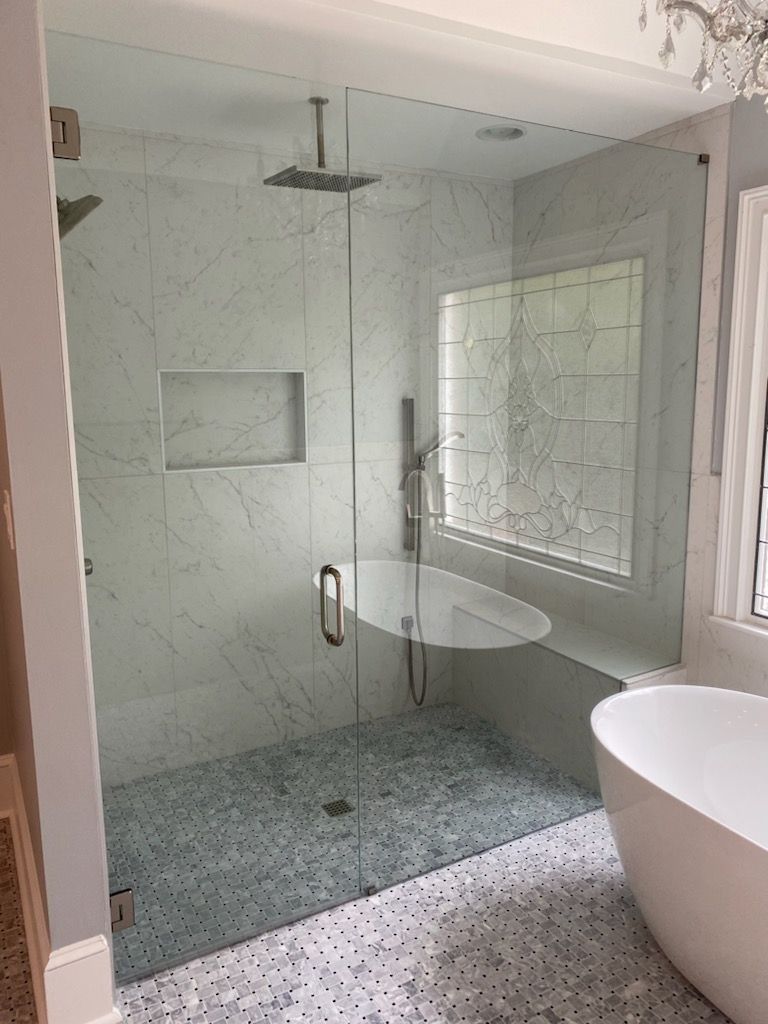 A bathroom with a walk in shower and a bathtub.
