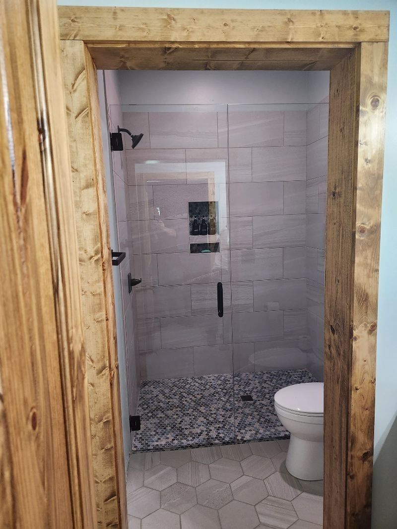 A bathroom with a walk in shower and a toilet.