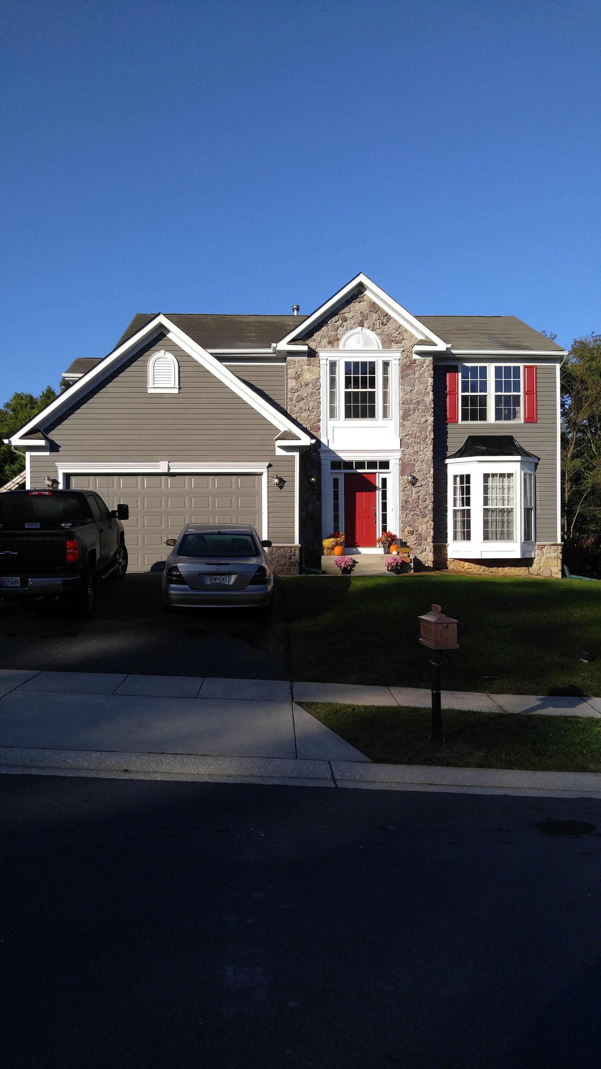 A large house with two cars parked in front of it