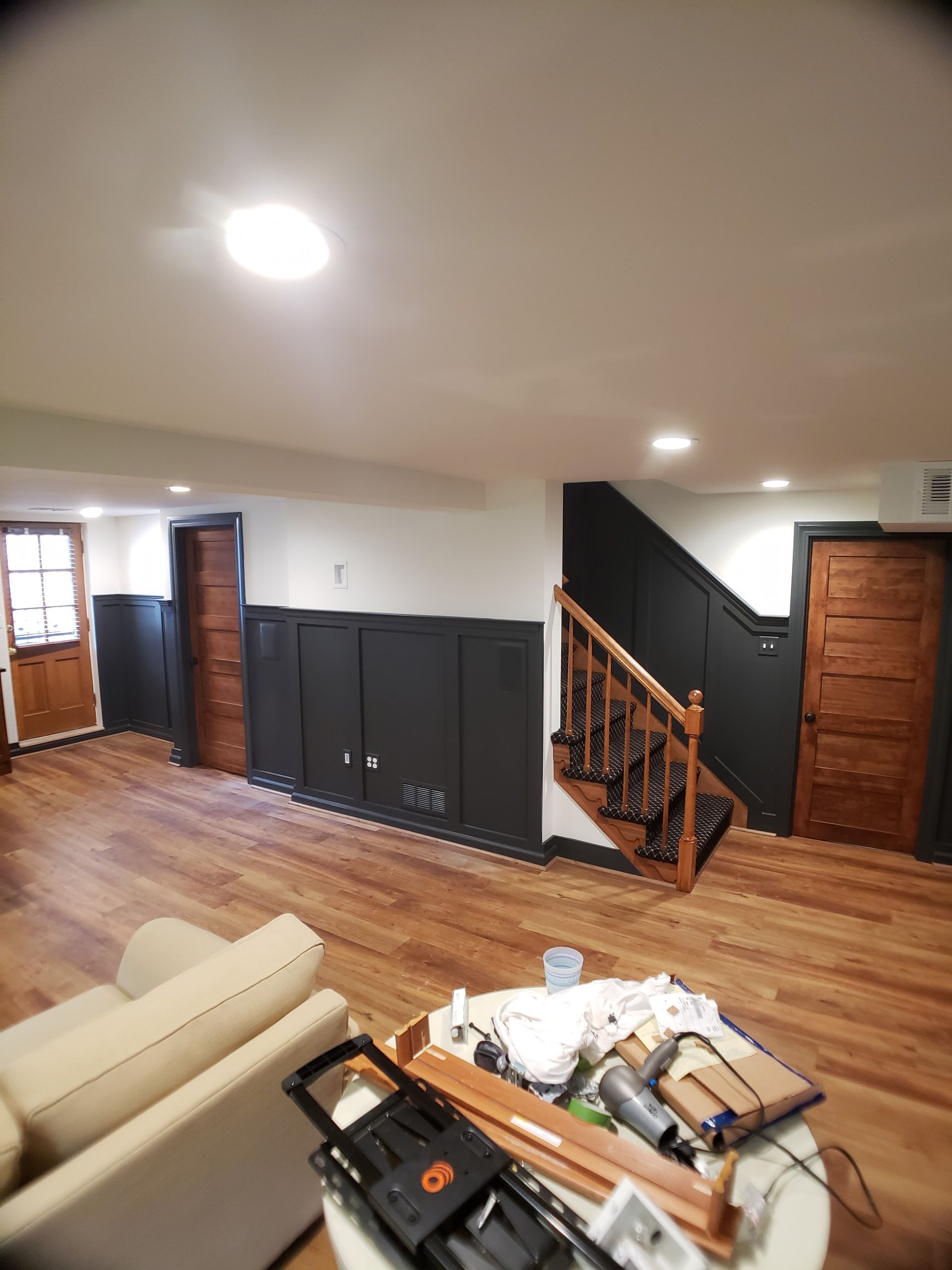A living room with a couch , table and stairs.