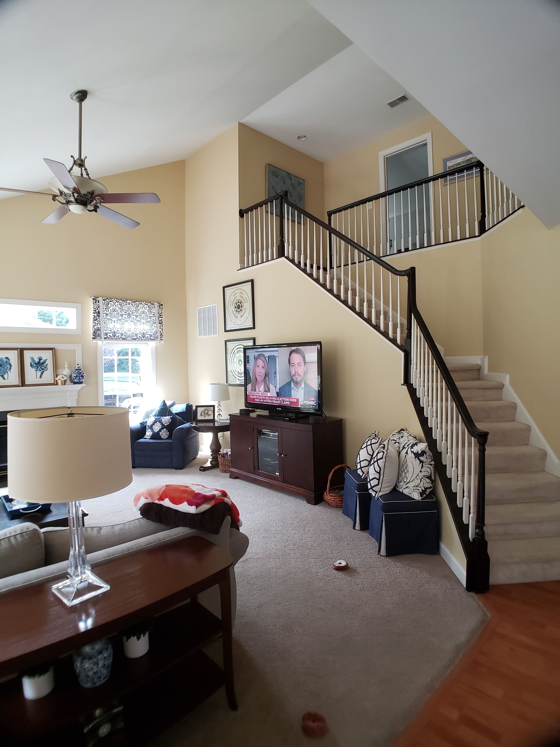 A living room with stairs and a flat screen tv