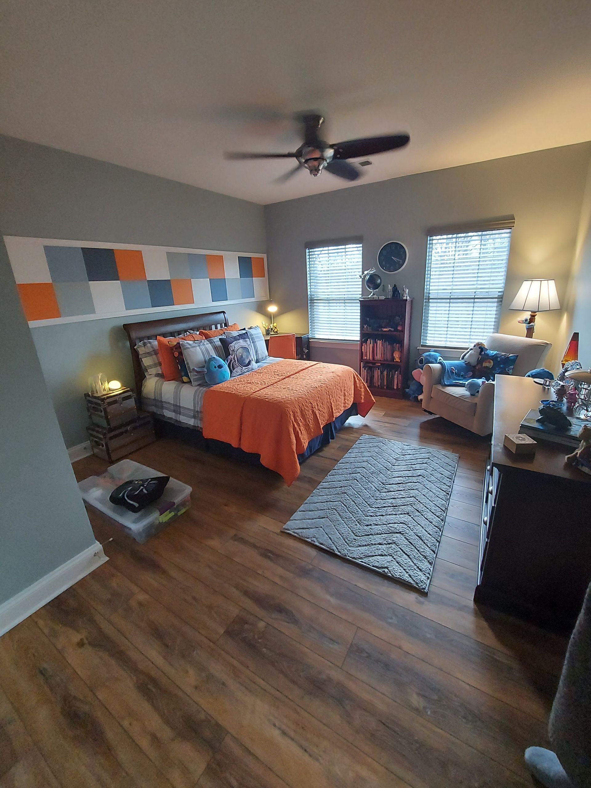 A bedroom with a bed and a ceiling fan.