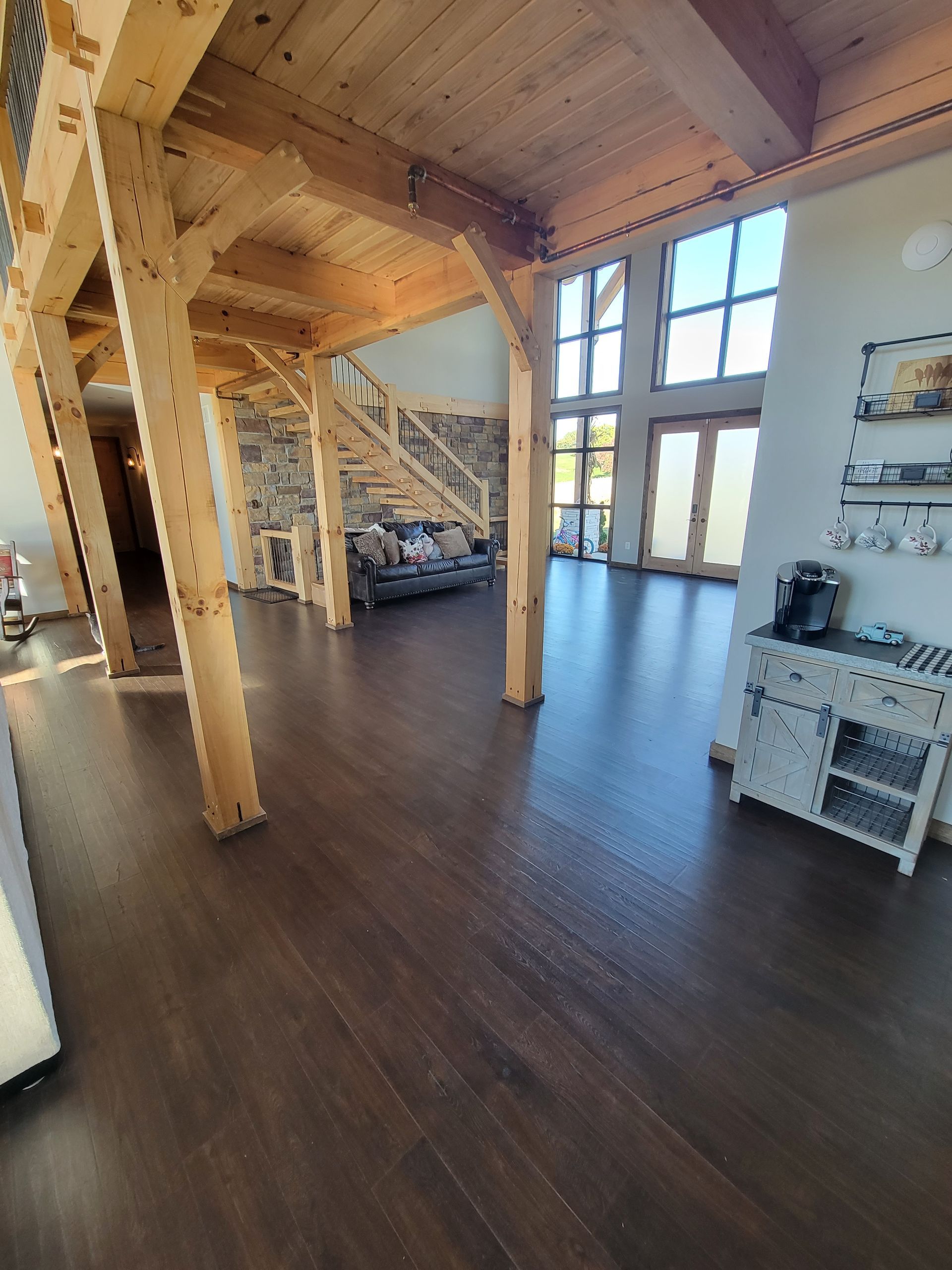 A large living room with hardwood floors and wooden beams.