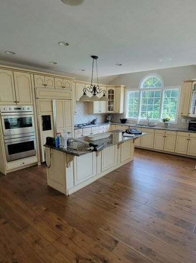 A large kitchen with white cabinets and stainless steel appliances.