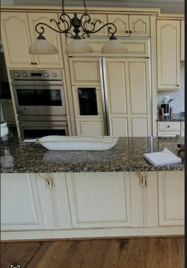 A kitchen with white cabinets and granite counter tops