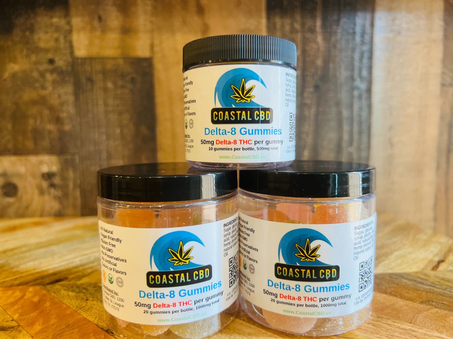 Three jars of delta 8 gummies are sitting on a wooden table.
