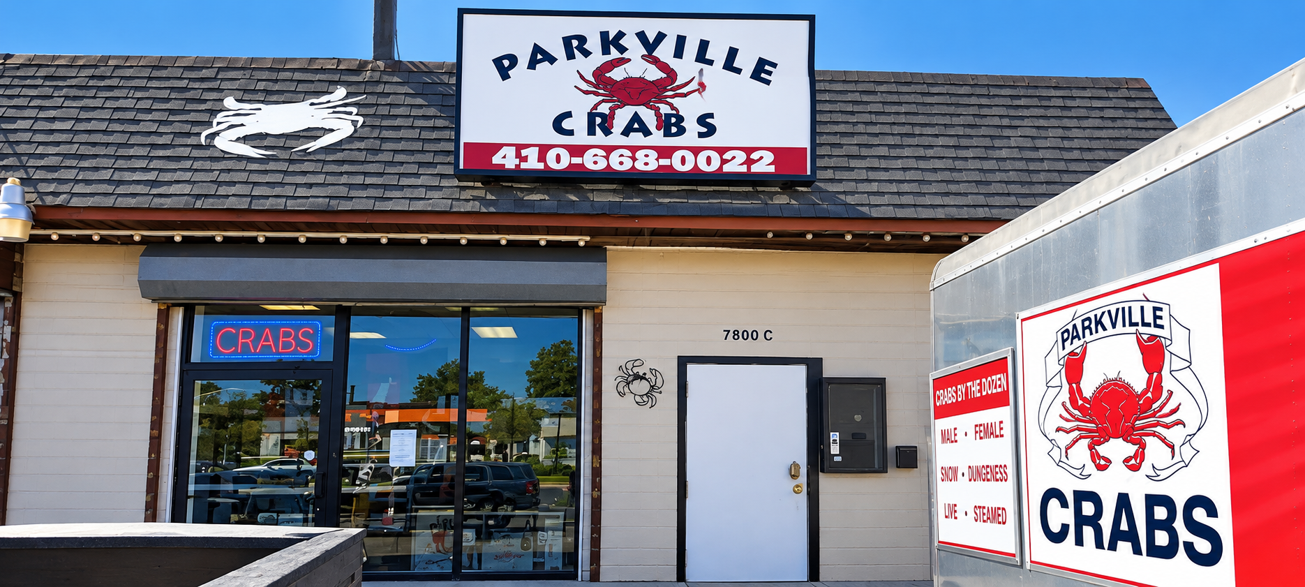 Parkville Seafoods storefront with crab signs and a large red crab graphic on a white truck