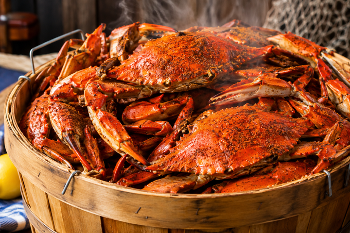 Basket of cooked crabs seasoned with red spices on a rustic table