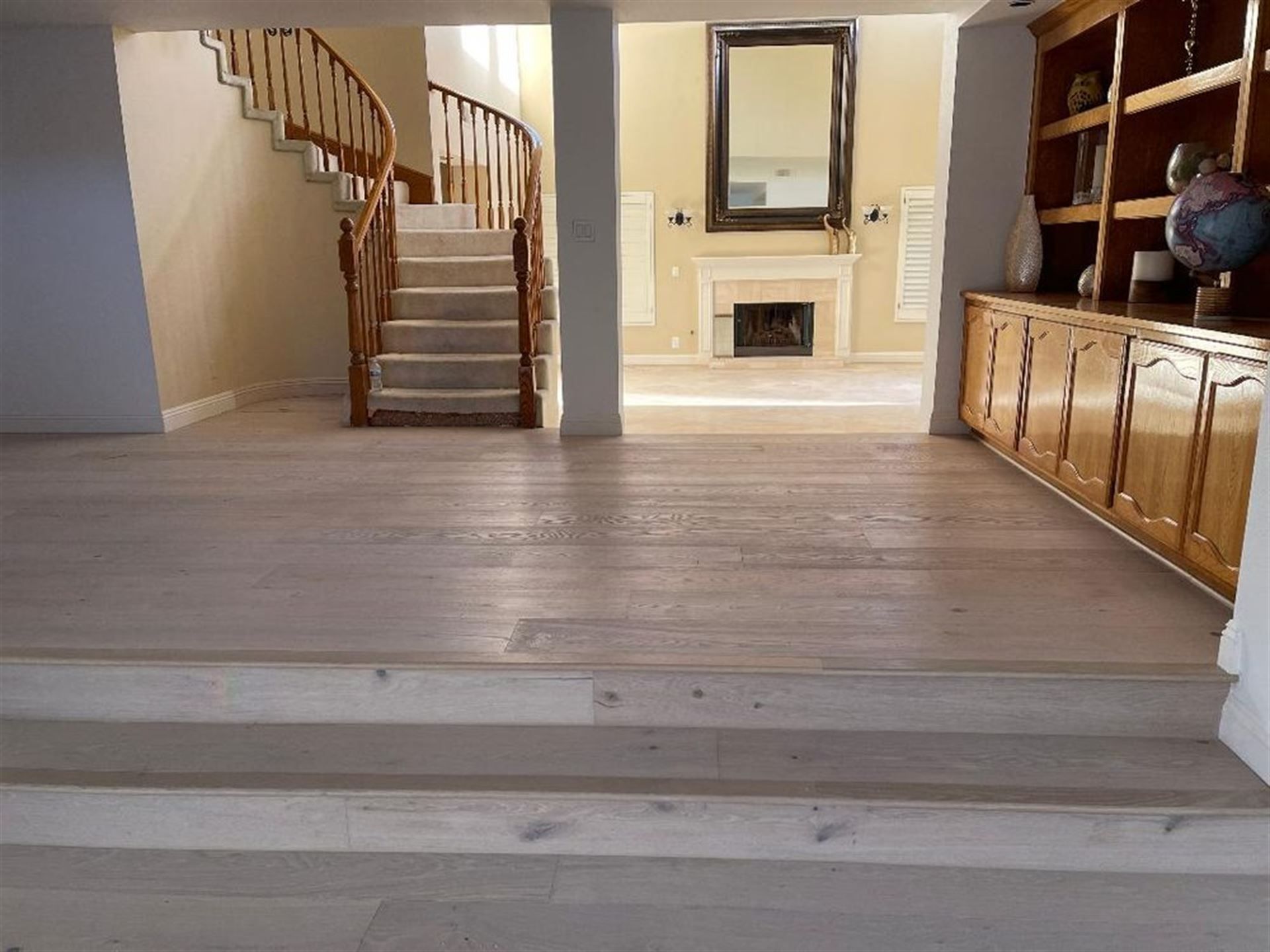 A living room with a staircase and a fireplace