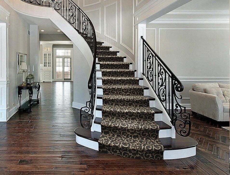 A curved staircase with a wrought iron railing in a living room