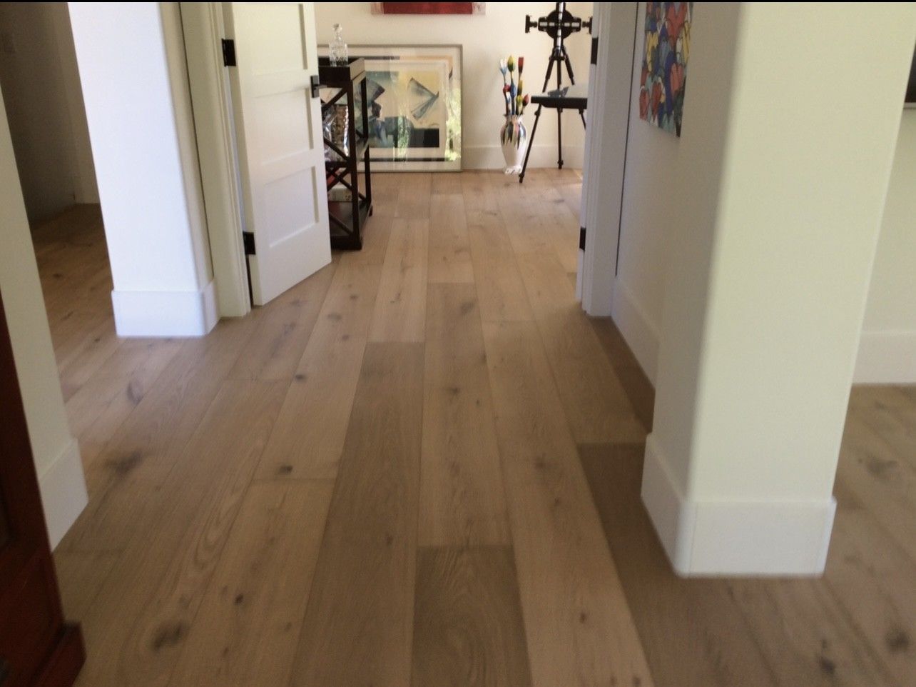 A hallway with a wooden floor and white trim