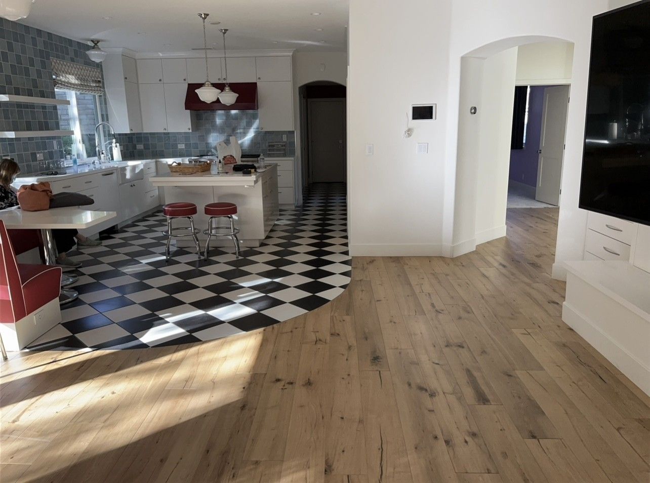 A kitchen with a checkered floor and wooden floors