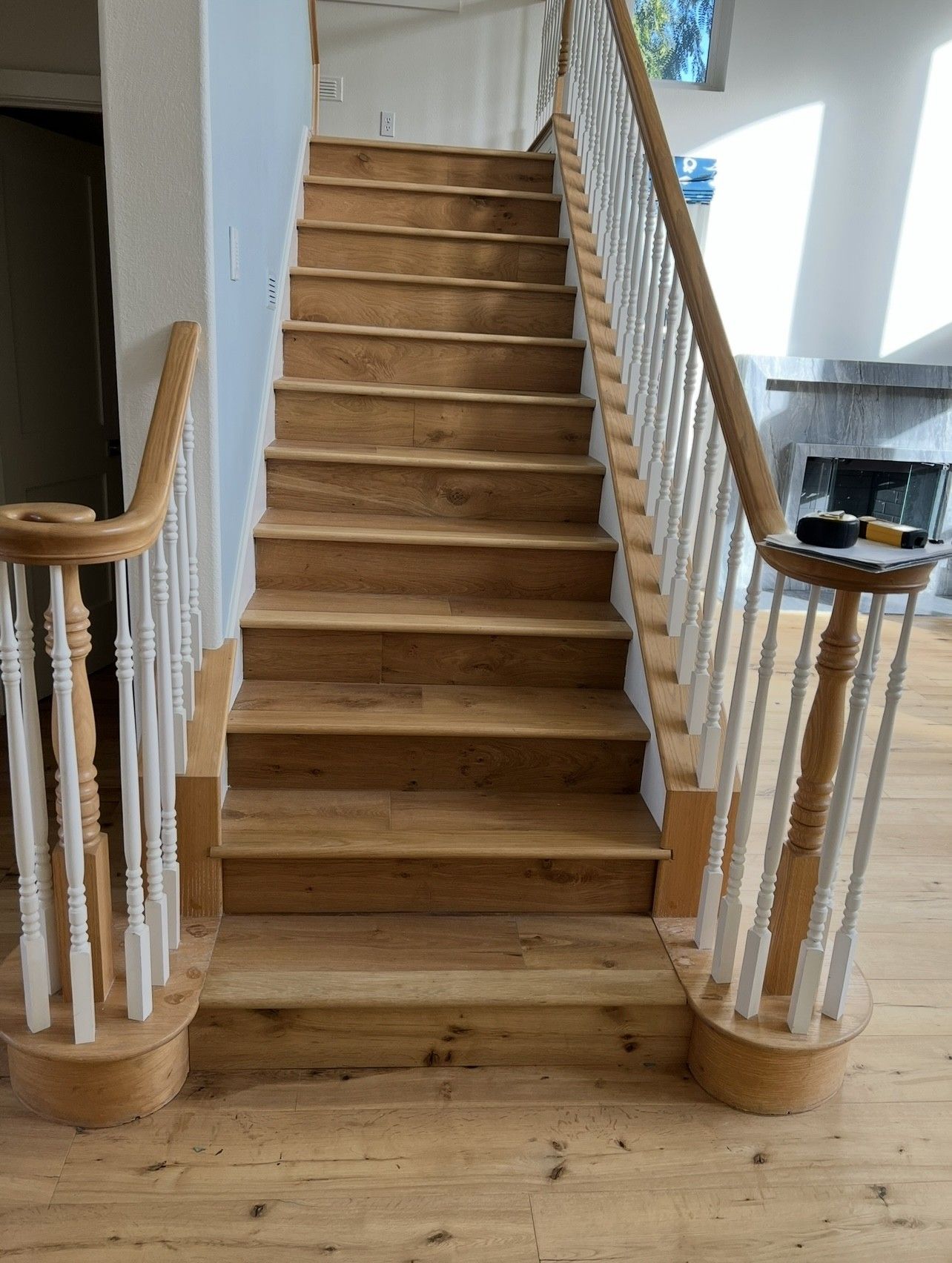 A wooden staircase with a white railing in a living room.