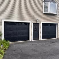 A house with two black garage doors and a window