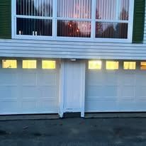 A house with a white garage door and a large window