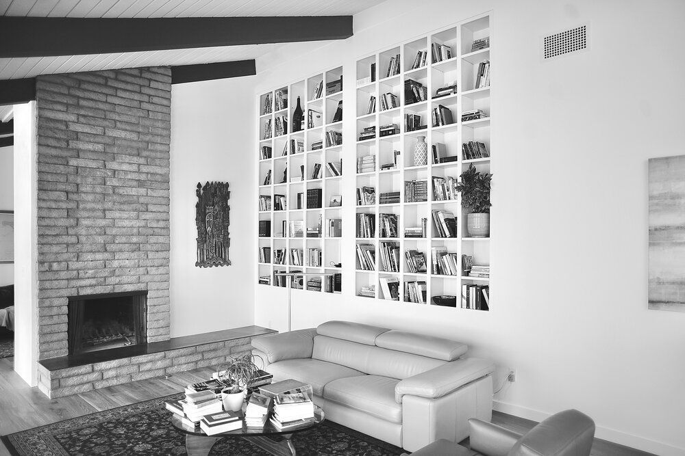 A black and white photo of a living room with a couch and a fireplace