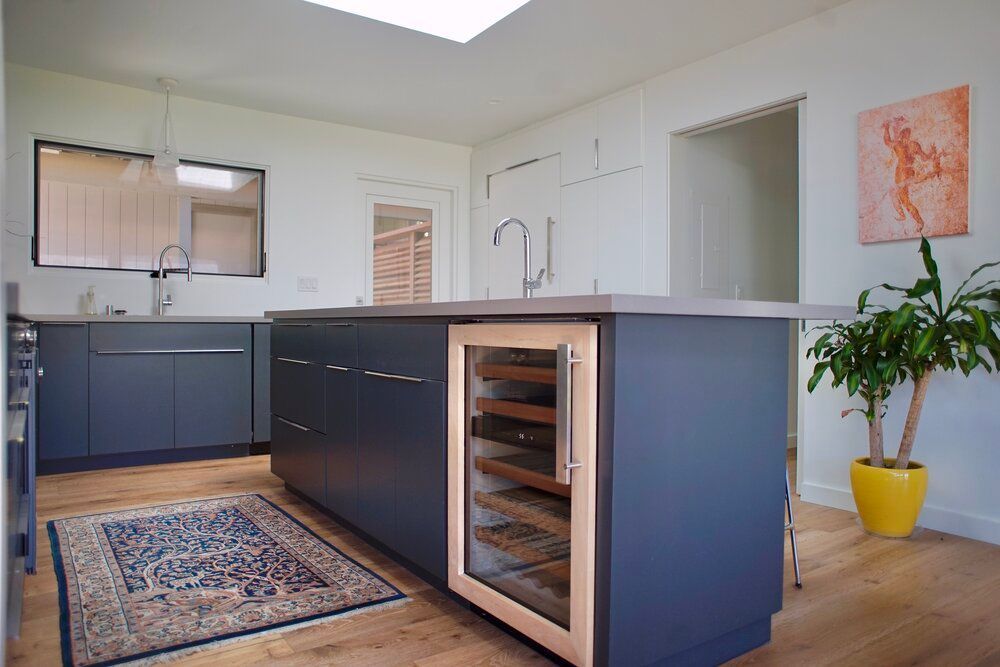 A kitchen with a large island and a wine cooler