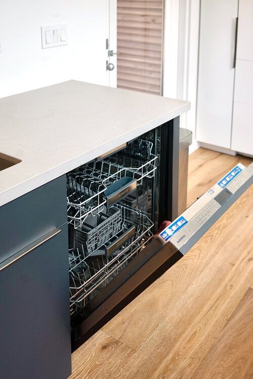 A dishwasher is open in a kitchen with the door open.
