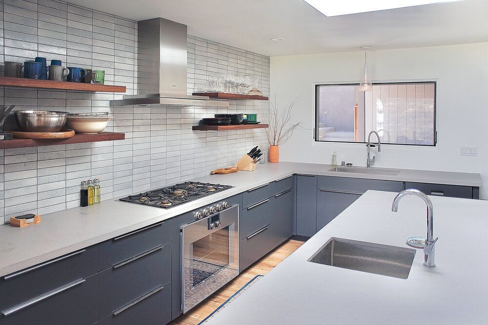 A kitchen with stainless steel appliances and gray cabinets