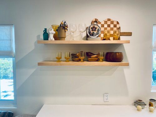 A kitchen with two shelves filled with bowls and glasses.