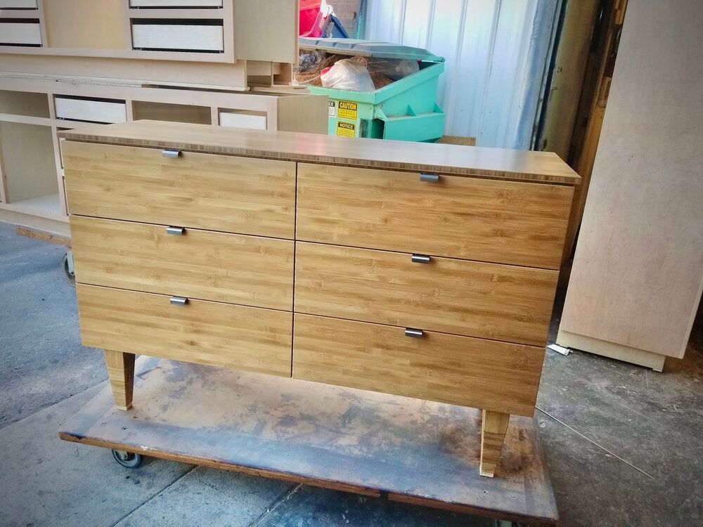 A wooden dresser is sitting on top of a wooden cart.