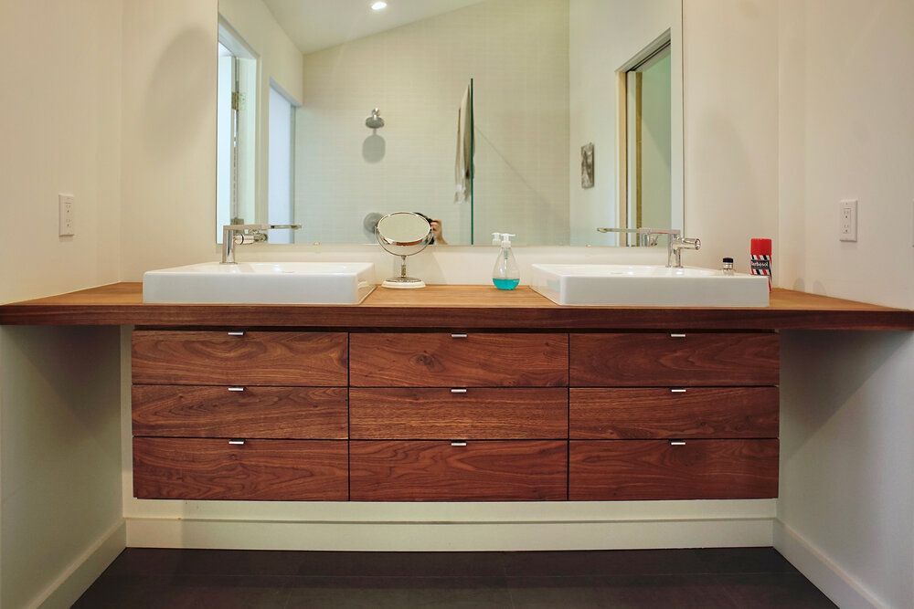 A bathroom with two sinks and a mirror.