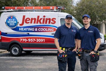 Two HVAC technicians standing in front of a Jenkins Heating & Cooling service van with red and blue branding