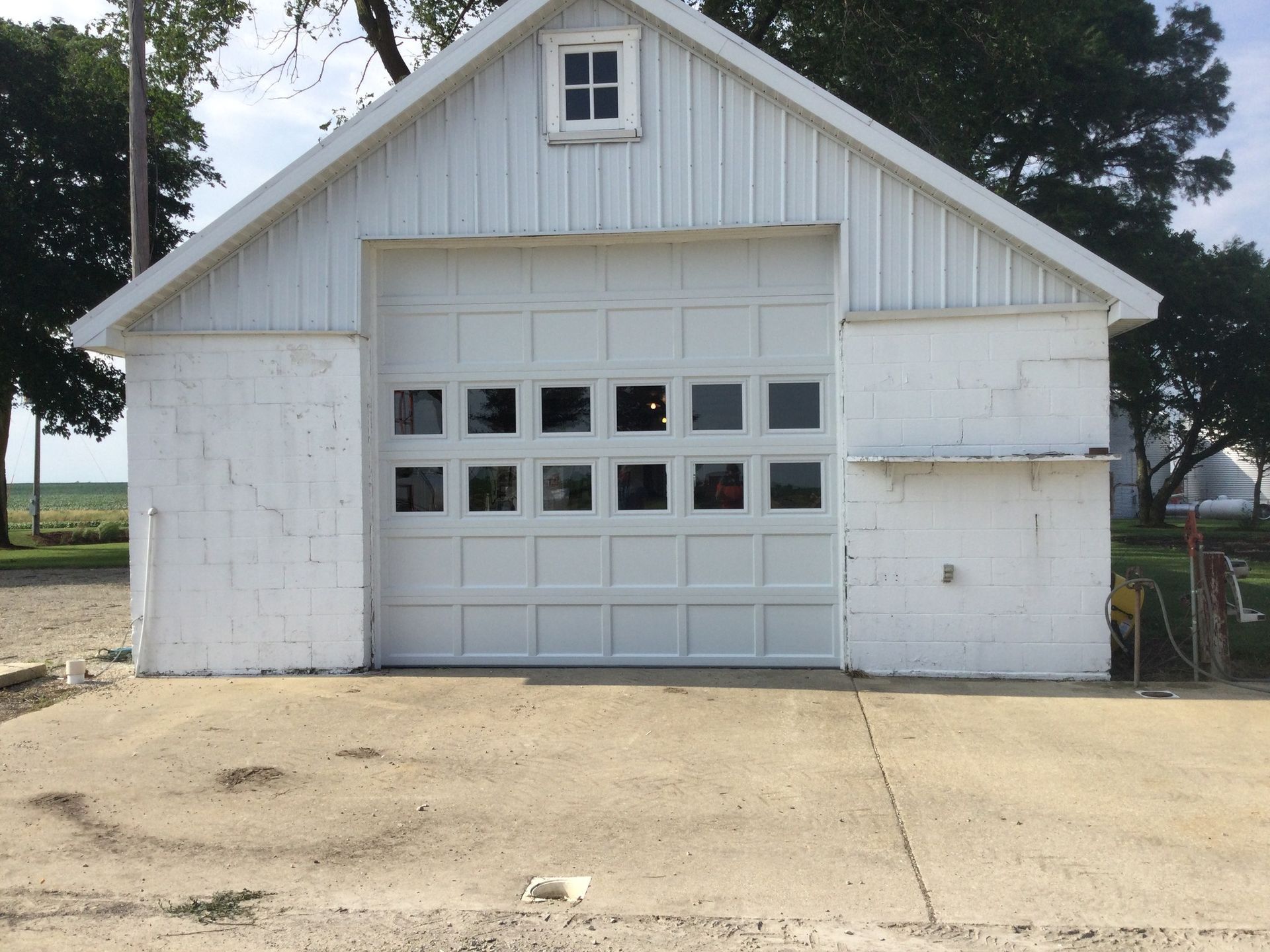 a white garage with a large garage door and a window