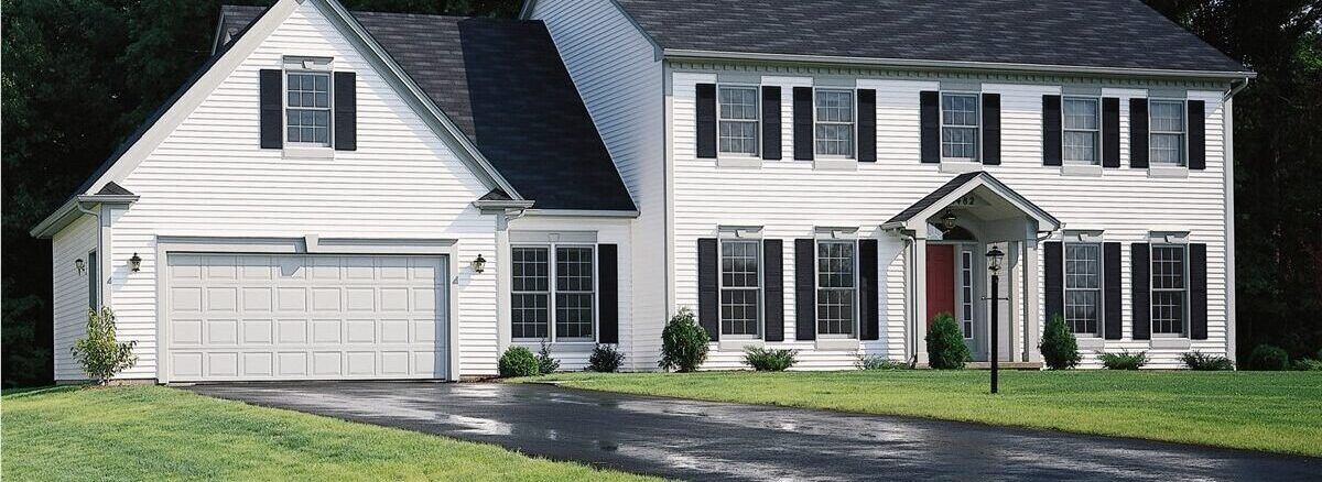 a white house with black shutters and a garage