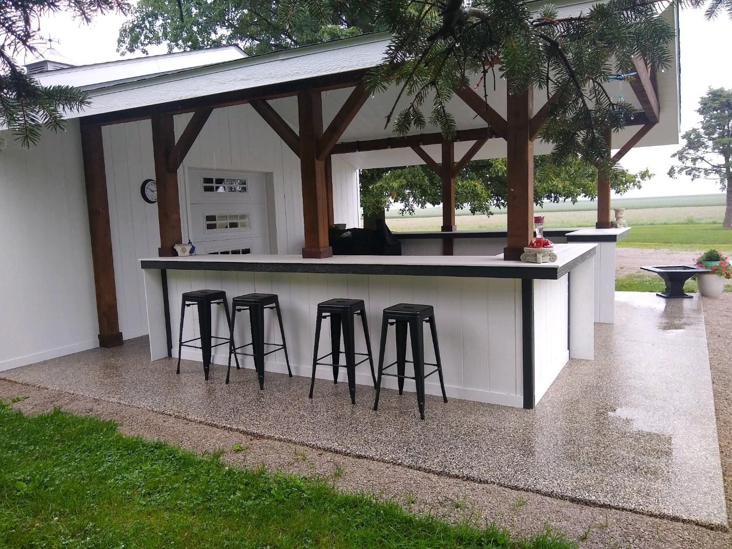 a kitchen with a long counter and stools under a canopy