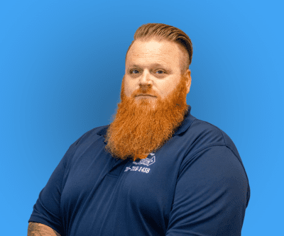 Man with a red beard in a navy shirt against a blue background
