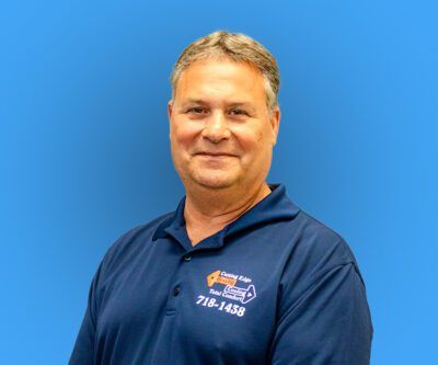 Man in a navy polo shirt smiling against a blue background
