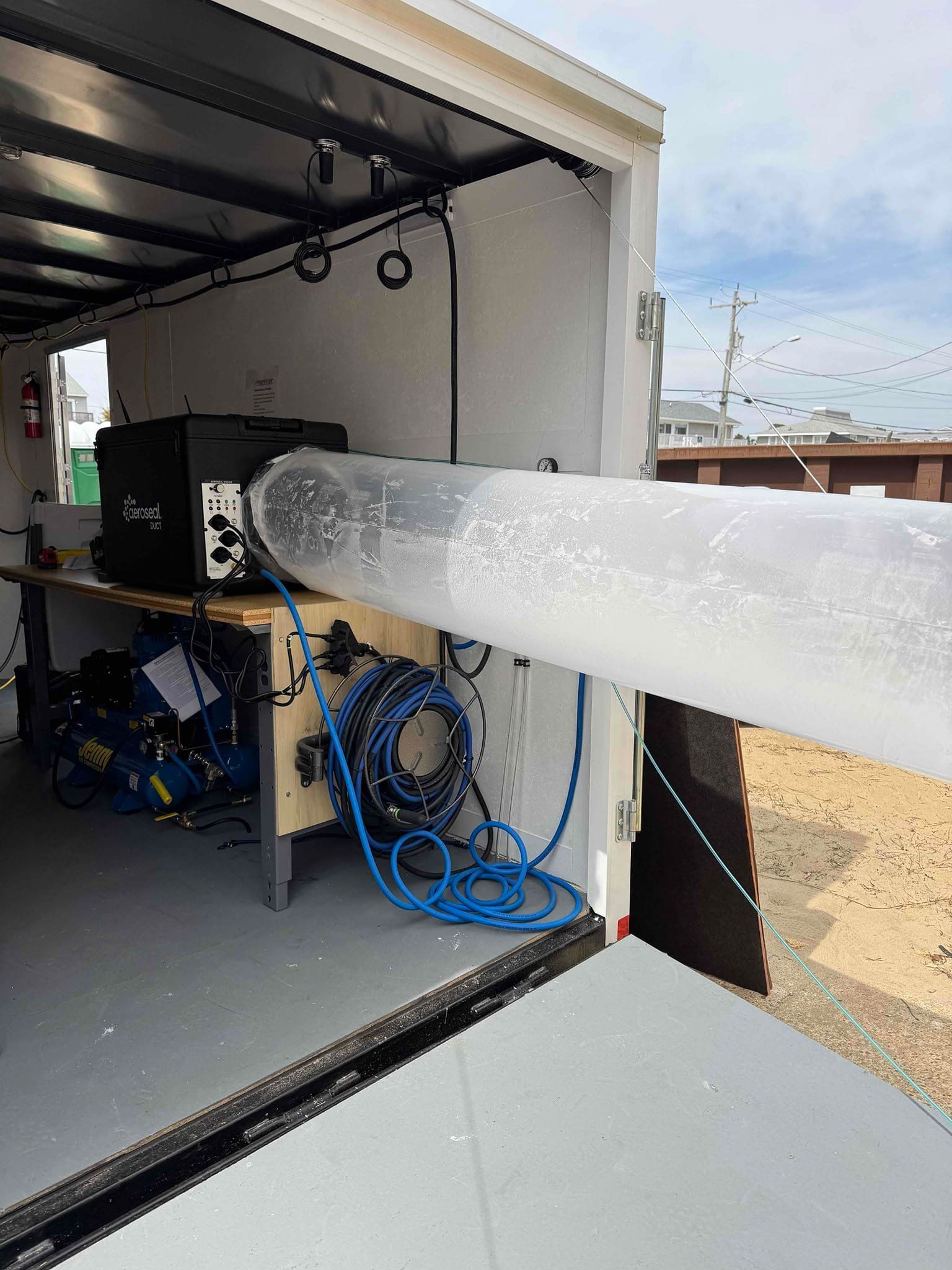 Icy transparent tube extending from a trailer interior into a sunny outdoor area