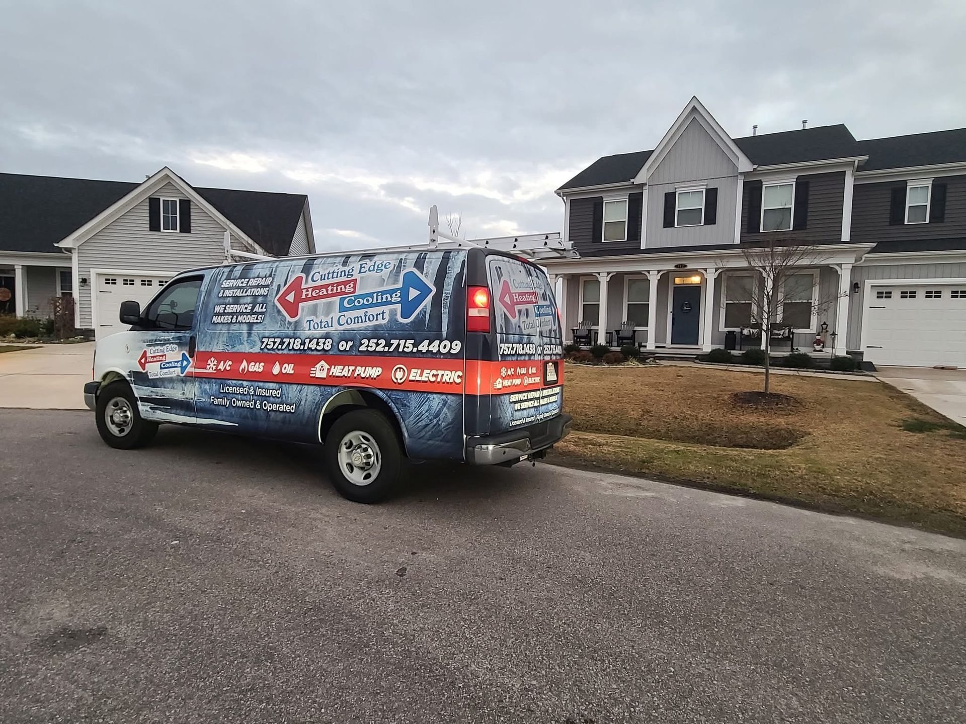 Wrapped service van parked in front of suburban houses on a cloudy day
