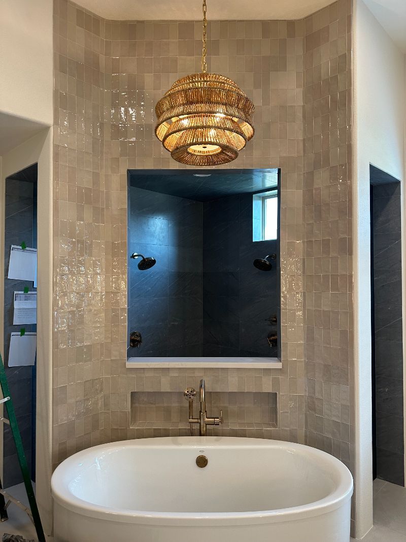 A bathroom with a bathtub and a large mirror.