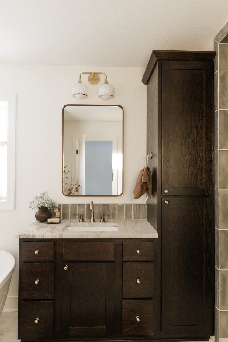 A bathroom with a sink , mirror and cabinets