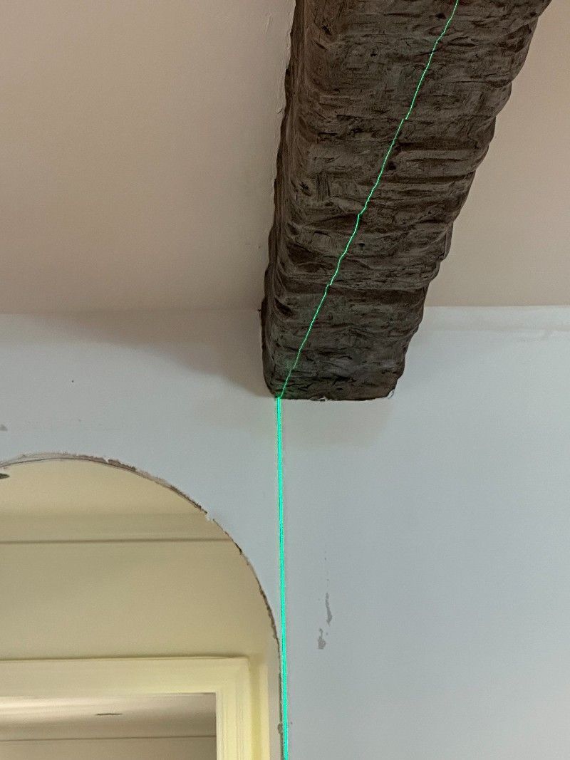 A green line is being measured on a wall next to a door.