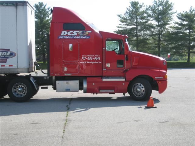 A red semi truck with the word dcsx on the side