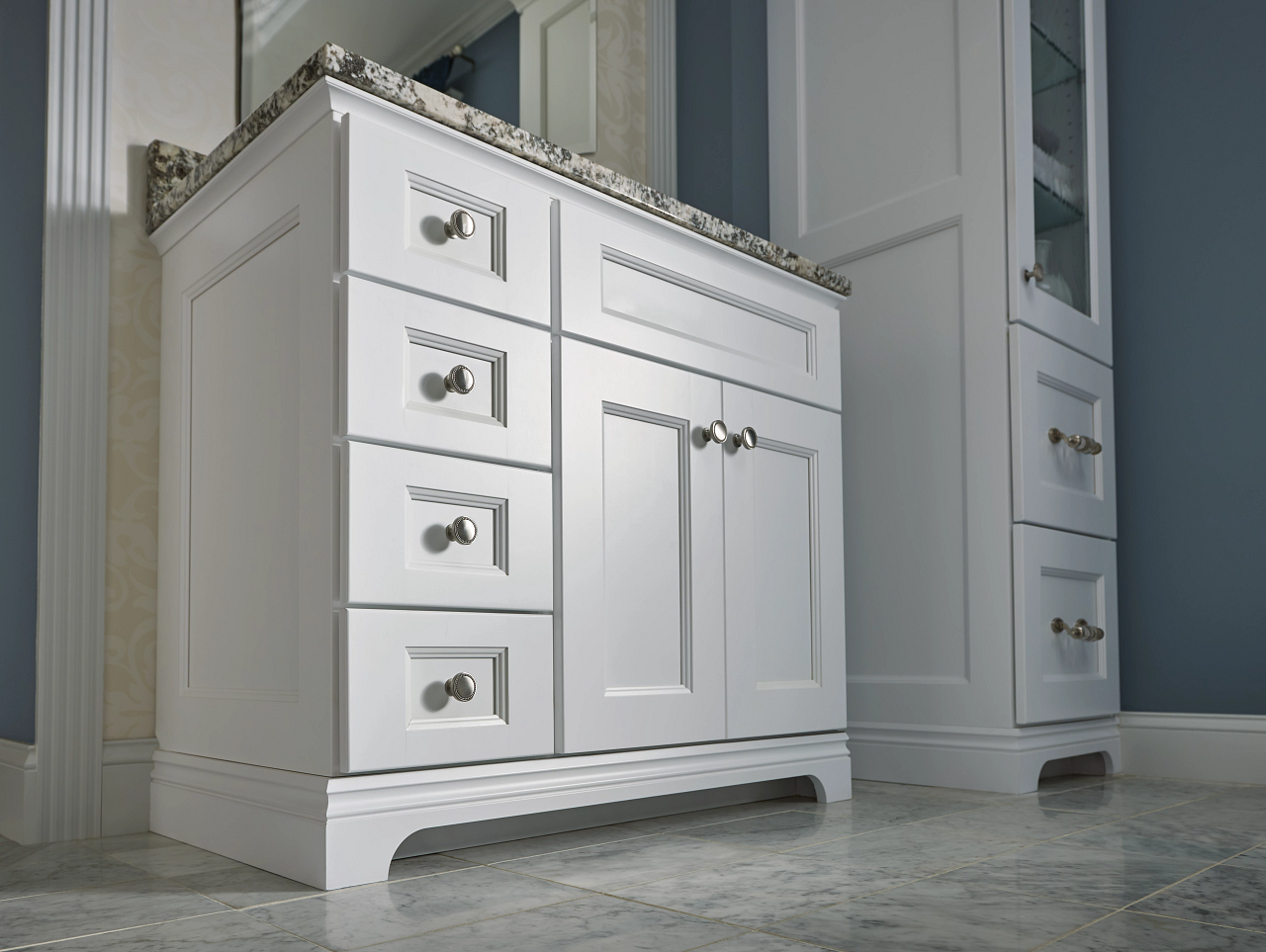 A bathroom vanity with drawers and a mirror